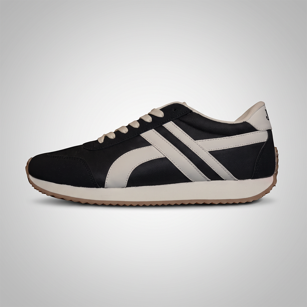 A black and off-white low-top sneaker shown from the side profile against a light gray gradient background.